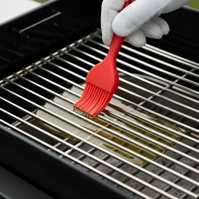 Applying high-smoke point oil evenly to charcoal grill grates for seasoning